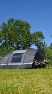 Graues Tunnelzelt auf grüner Campingwiese