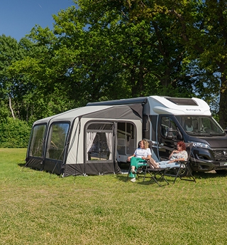 Wohnmobil mit Vorzelt auf sonnigem Campingplatz